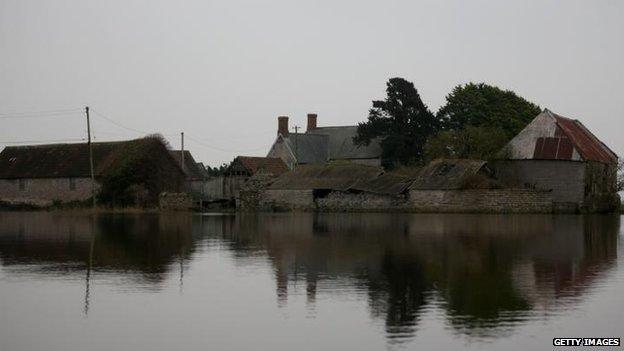 Farmer Roger Forgan and his partner Linda Maudsley (not pictured) use a boat to cross farm land to get from their farm (pictured) which has been cut off by flood waters near the village of Muchelney on January 30, 2014 in Somerset