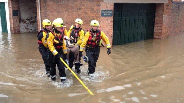 Lady in wheelchair carried through flood