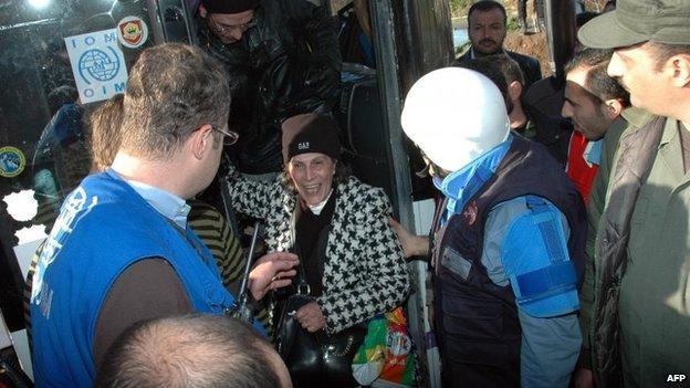 Syrian civilians disembark a bus after they were evacuated from rebel-controlled districts that were besieged by the army in the central Syrian city of Homs on Wednesday