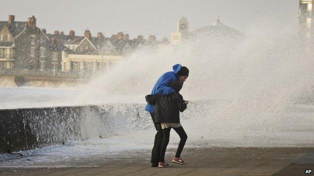 Two people struggle to make their way along the Esplanade, in Porthcawl, South Wales