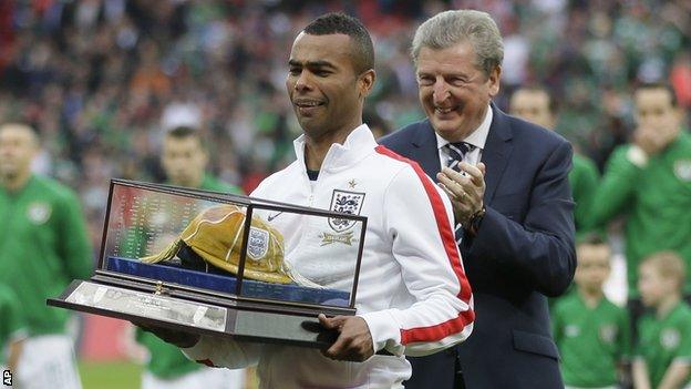 Ashley Cole, left, with a golden cap presented to him by manager Roy Hodgson, right, to mark his 100th cap for England.