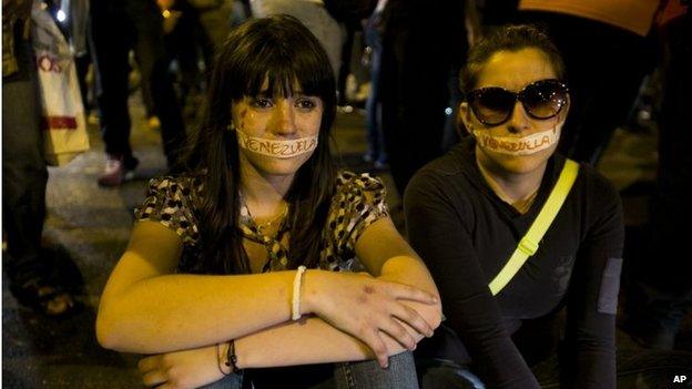 Protesters with their mouths covered with tape protest the detention of four students in Caracas (8 February 2014)