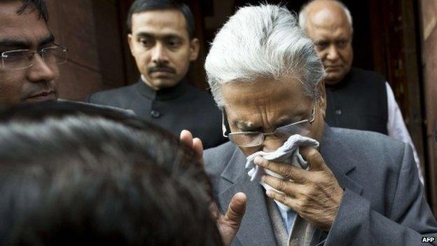 An unidentified member of India"s Parliament, holding a handkerchief to his face after being affected by pepper spray, leaves Parliament after protests inside the building in New Delhi on February 13, 2014.