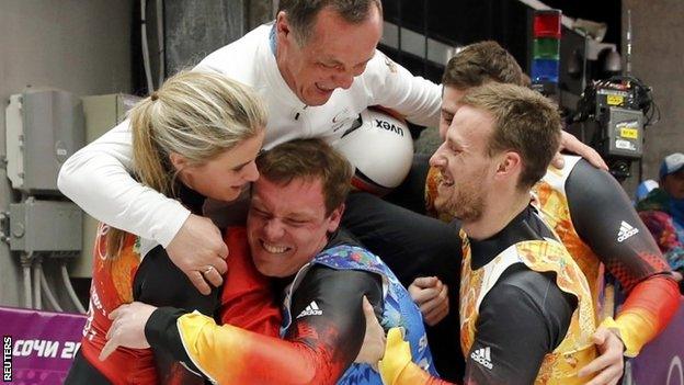 Germanys Natalie Geisenberger (left), Felix Loch, Tobias Wendt (front right) and Tobias Arlt (back right) carry their coach Norbert Loch