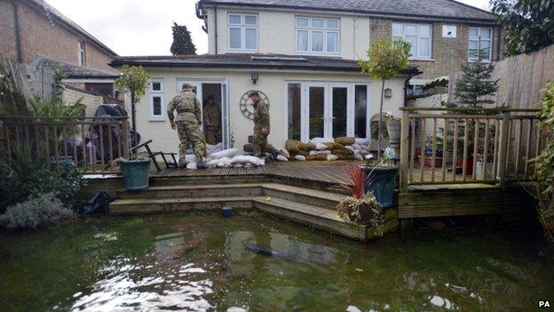 Soldiers from the Royal Welsh placing sandbags around a house in Chertsey, Surrey