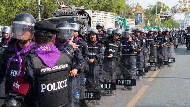 Police wait at the Rachadamnoen, Bangkok, on 14 February 2014