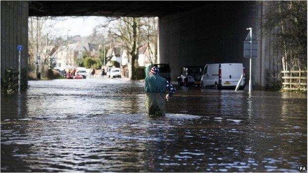 A man makes his way through flood water in Egham