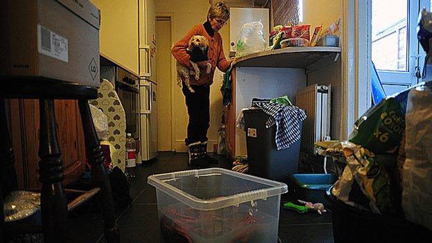 Karen washing her clothes in a plastic storage box