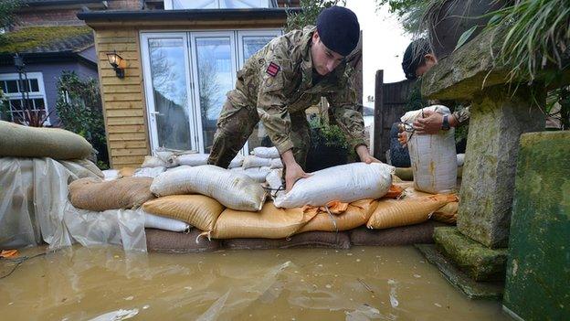 Handout photo issued by the Ministry of Defence of soldiers on Bridge Street, in Chertsey, placing sandbags around houses that are threatened with further flooding