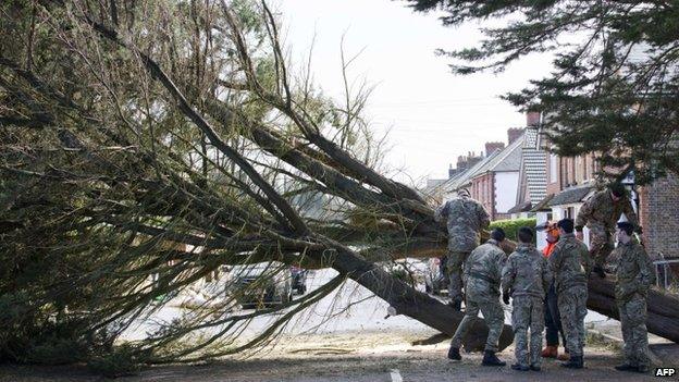 Soldiers try to move a fallen tree in Egham, Surrey