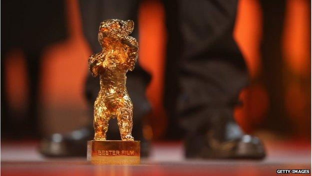 The Golden Bear for Best Film, on stage during the Berlin Film Festival, in front of someone's feet