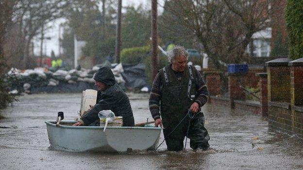 Moorland resident Derek Bristow pulls his wife Paula through flood water in his boat in the flooded village of Moorland on the Somerset Levels