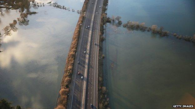 An aerial image of a motorway, with flooded land on either side