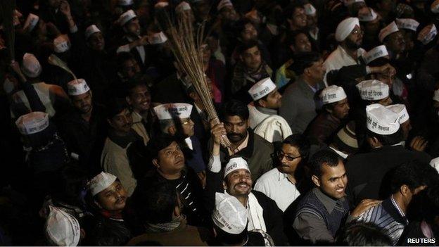 A supporter of Delhi"s Chief Minister Arvind Kejriwal, chief of the Aam Aadmi (Common Man) Party (AAP), holds a broom, the party symbol, at the party headquarters in New Delhi February 14, 2014