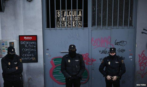 Police outside a home as they wait to carry out an eviction in Madrid December 11, 2013.