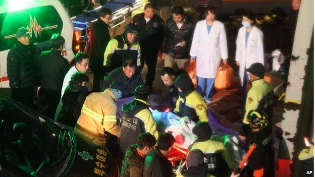 Rescue workers carry a victim, medical condition unknown, from the collapsed resort building