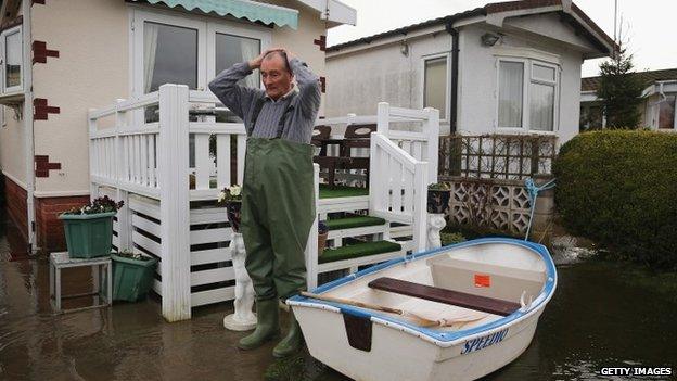 Man surveys flood damage at his Chertsey home, which backs on to the Thames