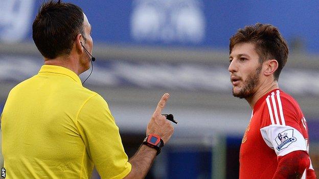 Mark Clattenburg (left) talks to Southampton's Adam Lallana