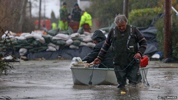 Moorland resident Derek Bristow pulls his wife Paula through flood water in his boat