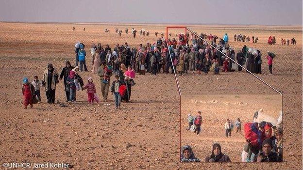 Photograph showing Marwan among group of other Syrian refugees crossing border with Jordan (16 February 2014)