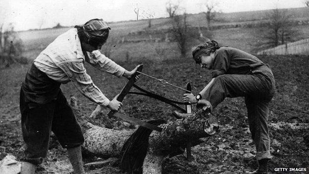 two land girls sawing a log