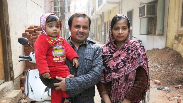 Haider Ali with his wife and son outside their home in New Delhi