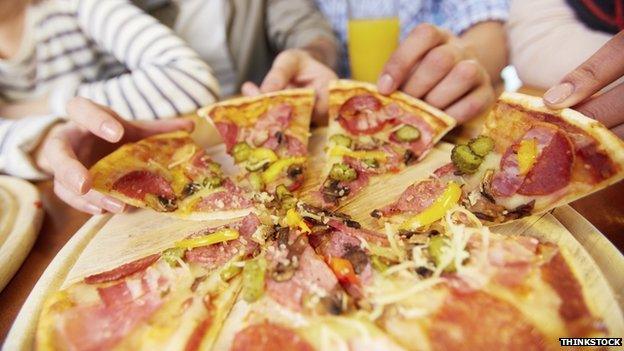 People taking a slice of pizza