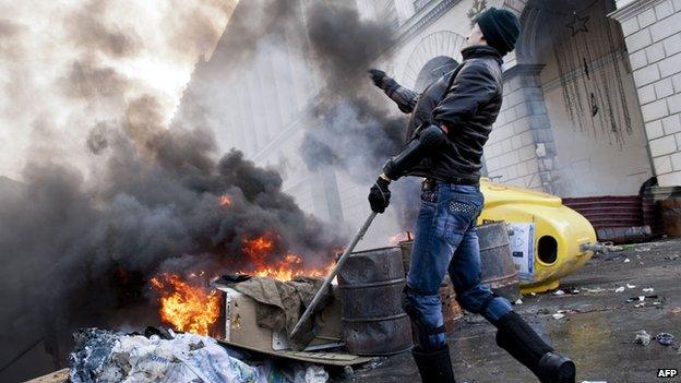 A Ukrainian protester throws a rock during clashes in Kiev