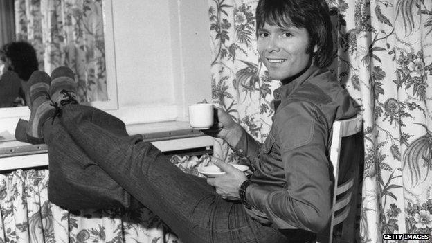 Pop star Cliff Richard relaxes with a cup of tea backstage, before the Royal Variety Performance at the London Palladium, 26 November 1973