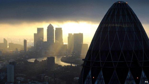 File photo dated 25/02/10 of the "Gherkin" and Canary Wharf at sunrise in the City of London