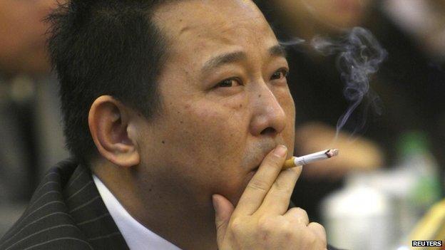 File photo: Liu Han, former chairman of Hanlong Mining, smokes a cigarette during a conference in Mianyang, Sichuan province, 21 March 2008