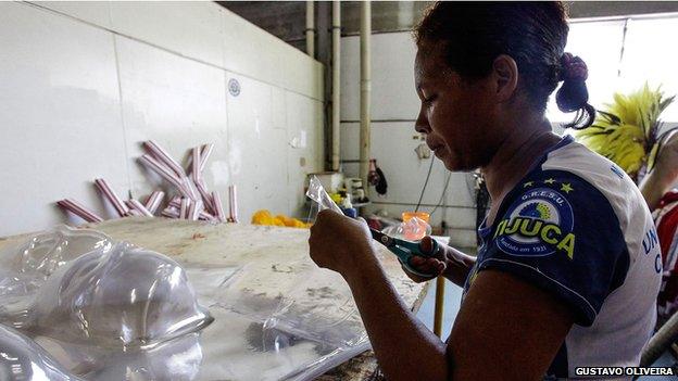 A woman works on costumes and decorations for the parade