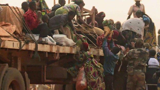 Muslim getting on to a truck, part of a convoy leaving Bangui to CAR