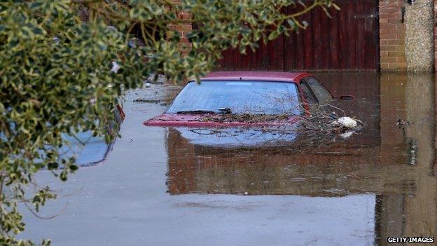 A car up to its wing mirrors in water