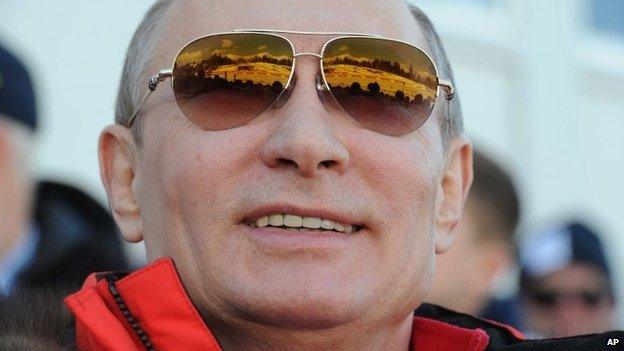 Russian President Vladimir Putin smiles as he watches the 4x10km cross-country relay at the 2014 Winter Olympics, Feb 16