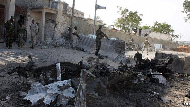 Soldiers stand guards outside the gate where a car bomb exploded