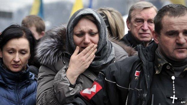 A woman weeps during a funeral service for the anti-government protesters