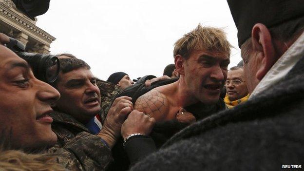 Anti-government protesters attack a man (C) whom they suspect of being a sniper