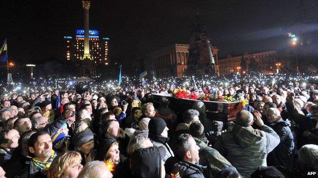 Crowds of protesters in Kiev with coffin of an activist killed in clashes