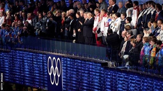 Russia's President Vladimir Putin waves next to International Olympic Committee (IOC) President Thomas Bach