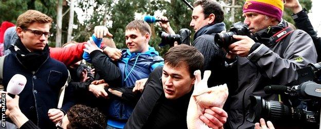 A member of a pro-Kremlin youth organisation throws a chicken during a press conference held by protest group Pussy Riot