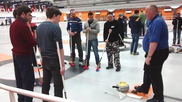 People taking curling lesson