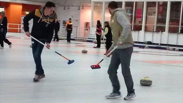 People taking curling lesson