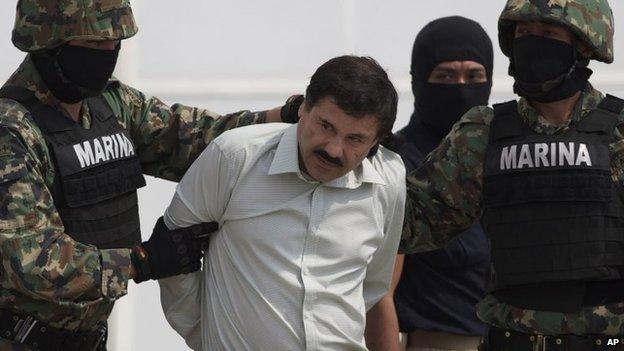 Joaquin Guzman is escorted to a helicopter in handcuffs by Mexican navy marines at a navy hanger in Mexico City on 22 February