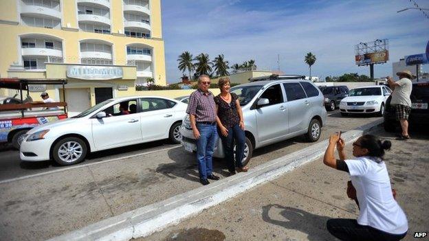 A couple poses for a photo in front of the Miramar apartment block in Mazatlan on 22 February, 2014