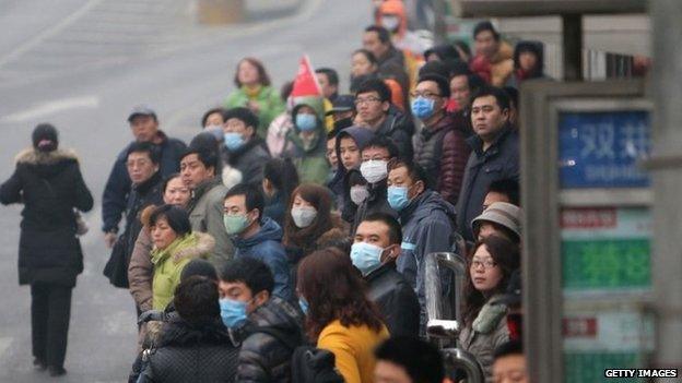 This picture taken on 24 February 2014 shows residents waiting for buses in a bus station in haze-covered Beijing