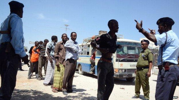 Somali soldiers frisk residents at a checkpoint in Mogadishu on February 22, 2014