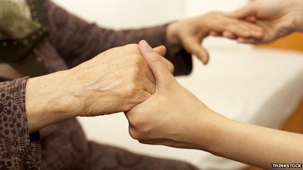 Old person holding hands with carer