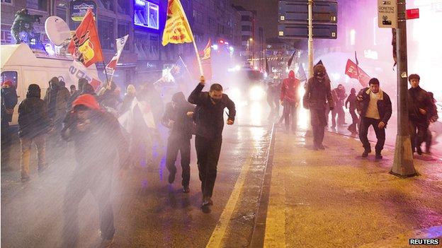 Protesters run away from water cannon and tear gas used by riot police during a demonstration against Turkey' Prime Minister Tayyip Erdogan in Istanbul on 25 February 2014.