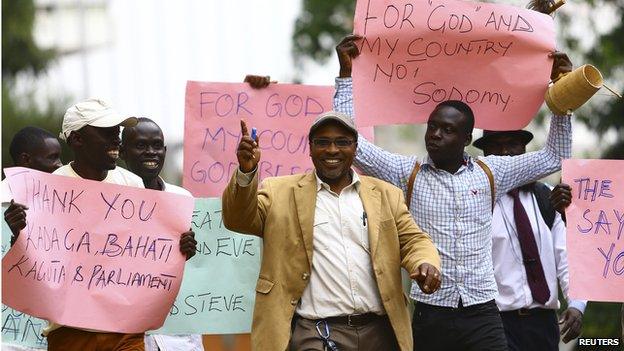 Ugandan anti-gay activist Pastor Martin Ssempa (C) leads anti-gay supporters as they celebrate after Uganda's President Yoweri Museveni signed a law imposing harsh penalties for homosexuality in Kampala on 24 February.